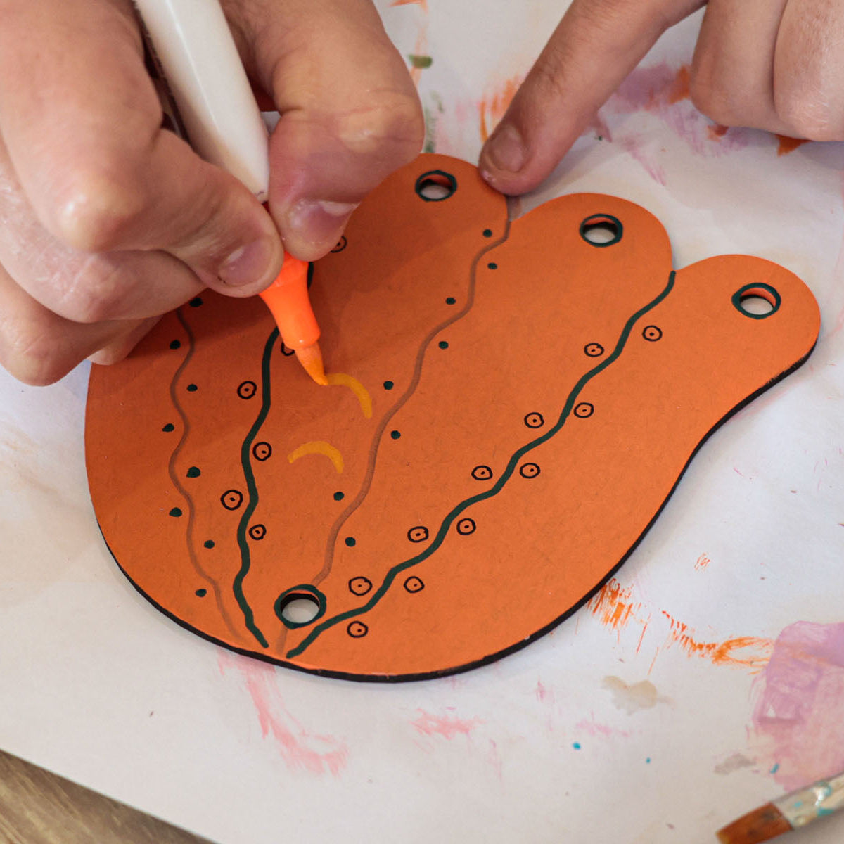 Person painting Jelly Fish laser cut out of MDF